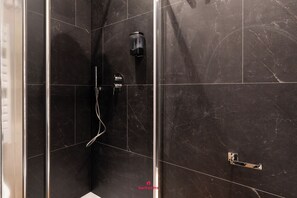 Deluxe tweepersoonskamer | Badkamer | Een douche, een haardroger, handdoeken, zeep