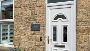 A stone facade with a white door, a nameplate reading "ARDBEG 7 ARGYLE TERRACE," and a window with shutters. - 2 bedroom accommodation in Hexham (Hexham)
