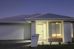 A residential house with a garage, a front door, and a mailbox.