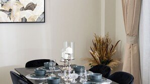 A dining table set with blue plates, clear glasses, and a silver candelabra. - Charming 2-bedroom apartment with AC in vibrant Dubai-Jumeira Village Circle (Dubai)