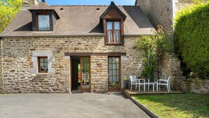 A stone building with a sloped roof, a small porch with chairs, and a clear entrance. - House - Le Clos Des Pommiers (Pleudihen-sur-Rance)