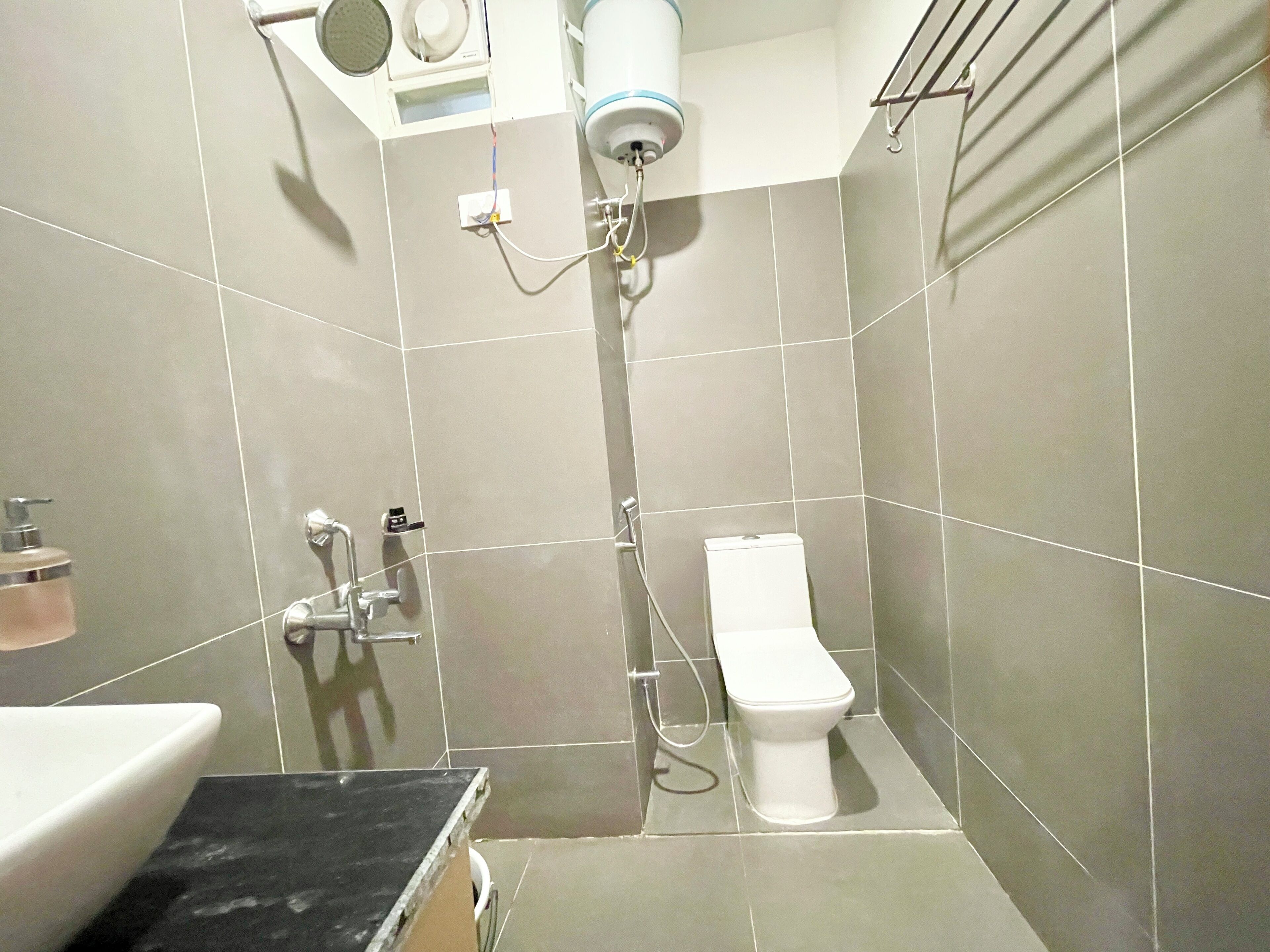A bathroom with a toilet, sink, and shower.