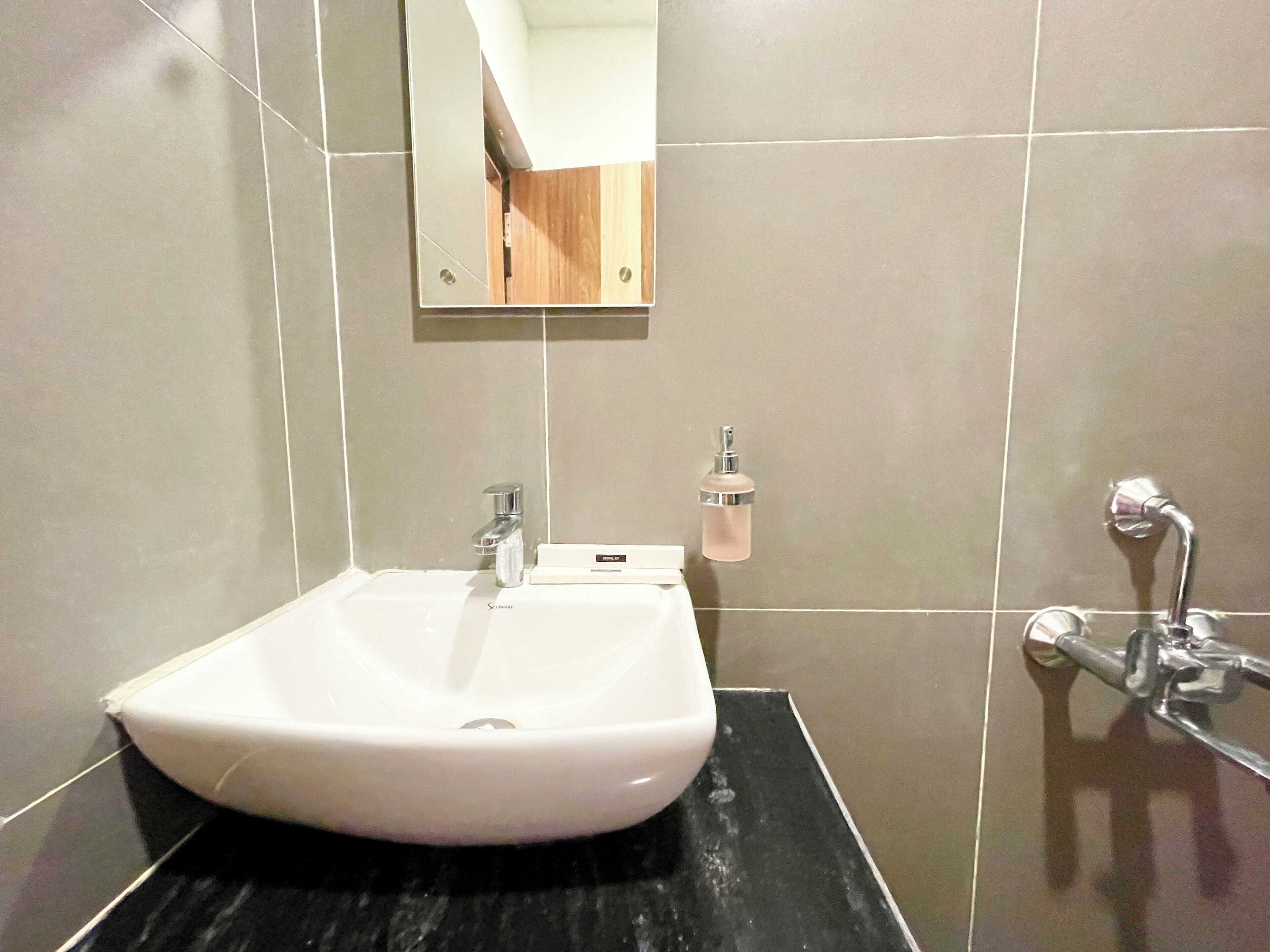 A bathroom with a white sink, a mirror, and a shower.