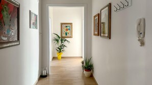 Un corridoio con quadri appesi, un telefono e piante in vaso.