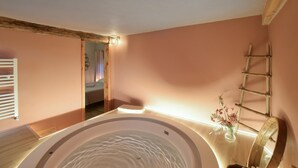 A spa room with a hot tub, wooden beams, a ladder, and a small flower vase. - 1 bedroom stunning apartment in Pieve di Teco (Pieve di Teco)