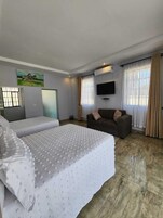 Family Suite, Garden View | In-room safe, desk, laptop workspace, iron/ironing board