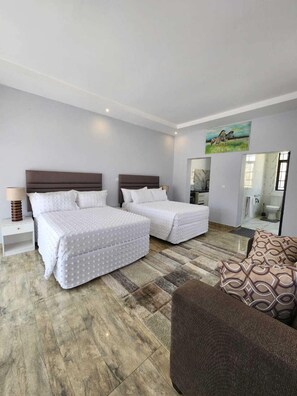 Suite familiare, vista giardino | Cassaforte in camera, una scrivania, postazione laptop