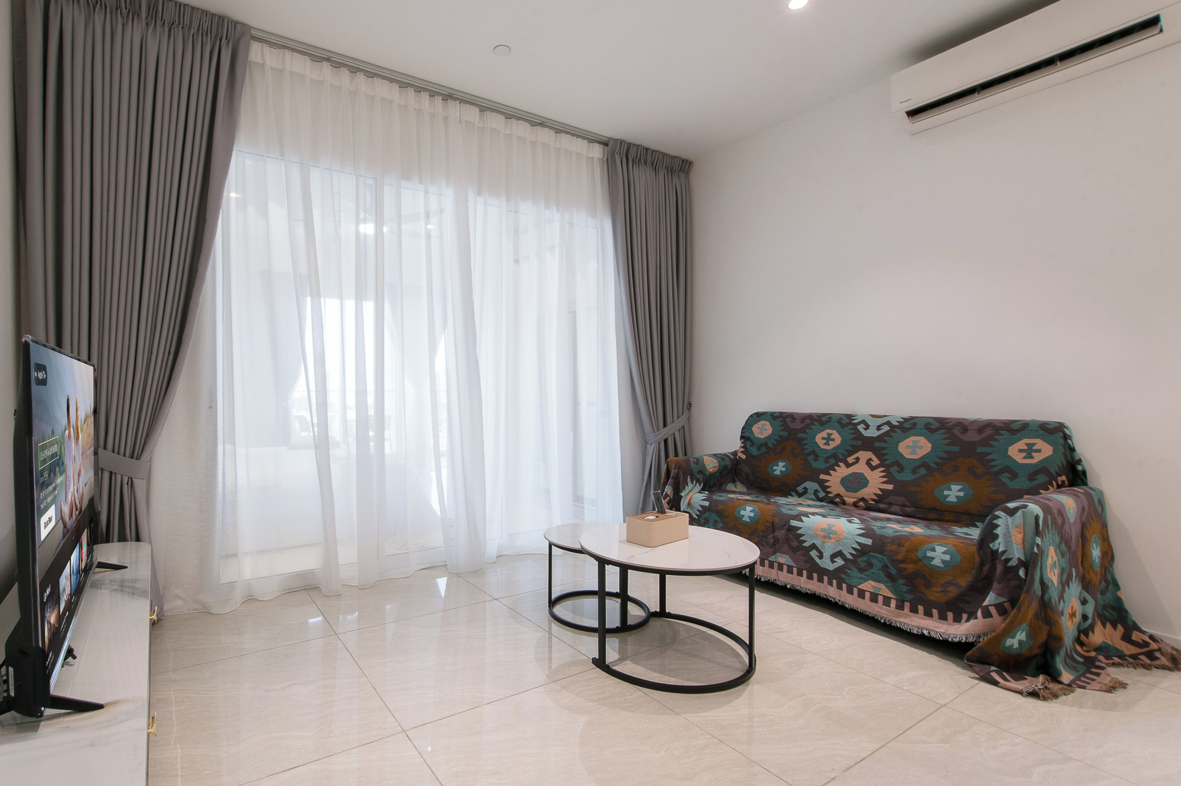 A living room with a sofa, a coffee table, and a TV.