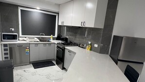 Una cucina moderna con microonde, piano cottura, lavastoviglie e frigorifero.