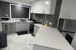 Una cocina moderna equipada con microondas, estufa, lavavajillas y refrigerador.