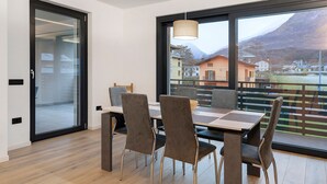 A modern dining area with a large window, a table, and four chairs.