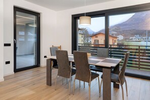 A modern dining area with a large window, a table, and four chairs.