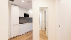 A modern kitchen with white cabinetry, a built-in microwave, and a dishwasher. - Apartamentos Silken Goya (Oviedo)