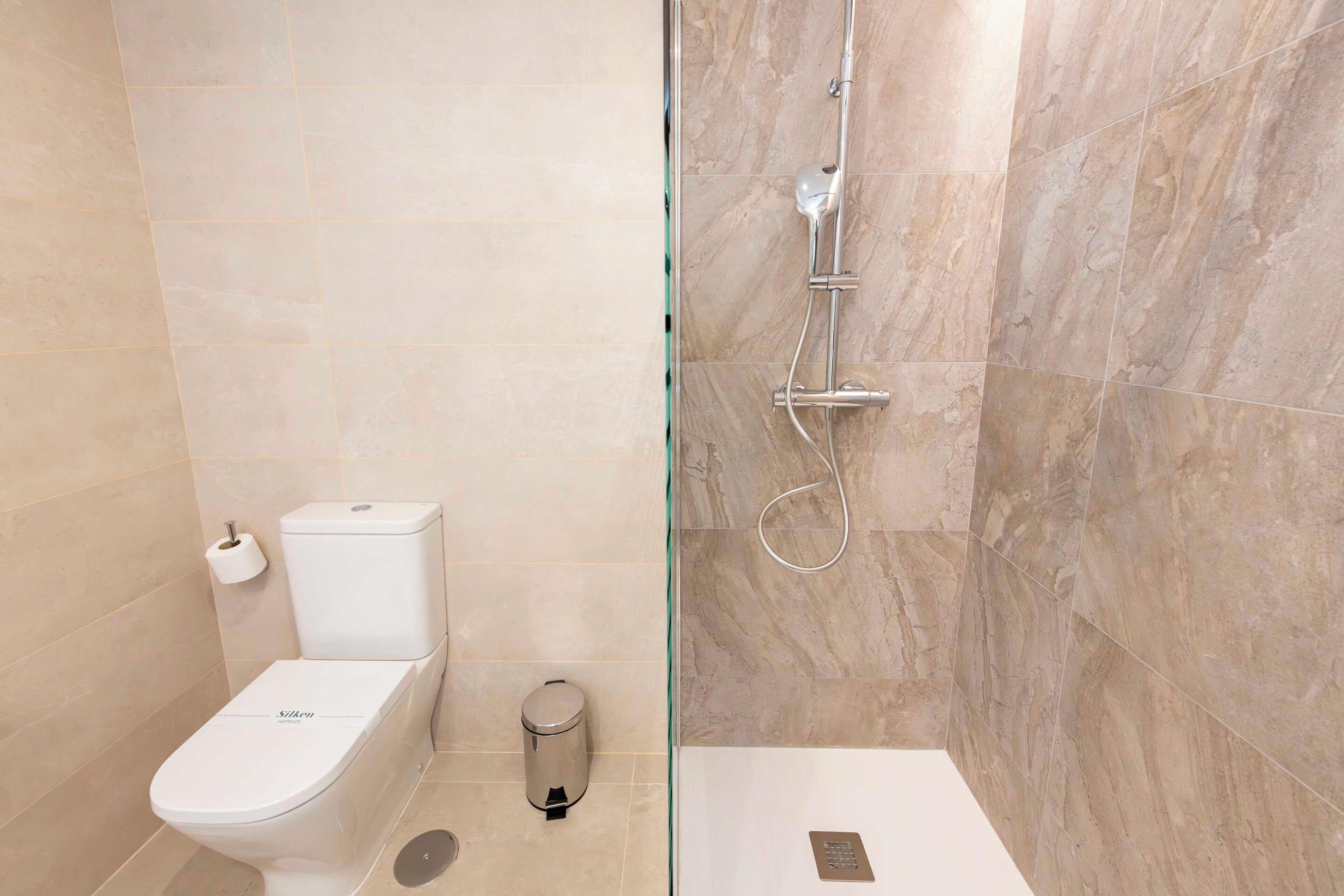 A modern bathroom with a toilet, bidet, and shower.