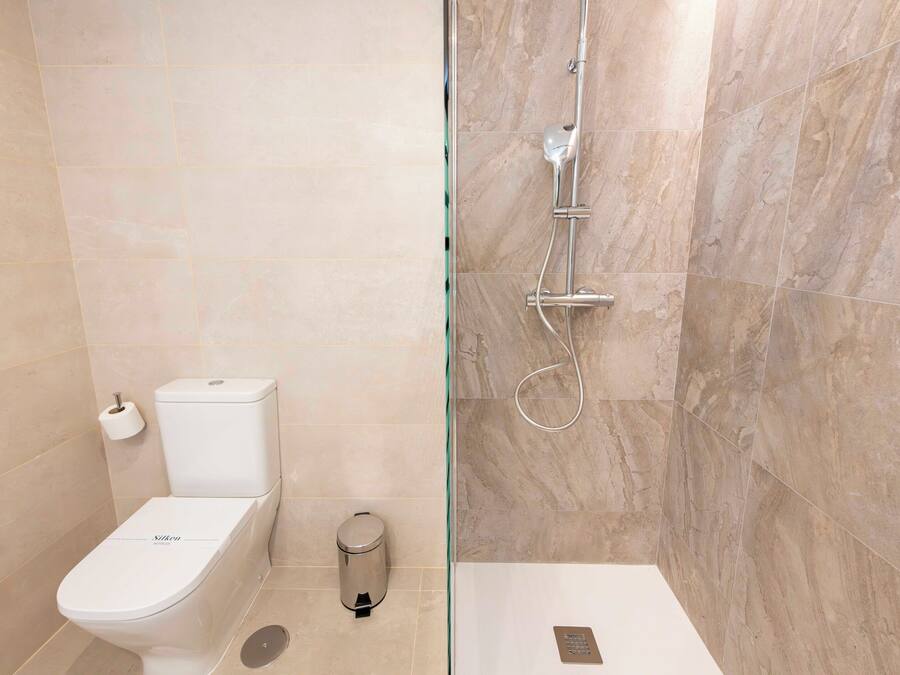 A modern bathroom with a toilet, bidet, and shower.