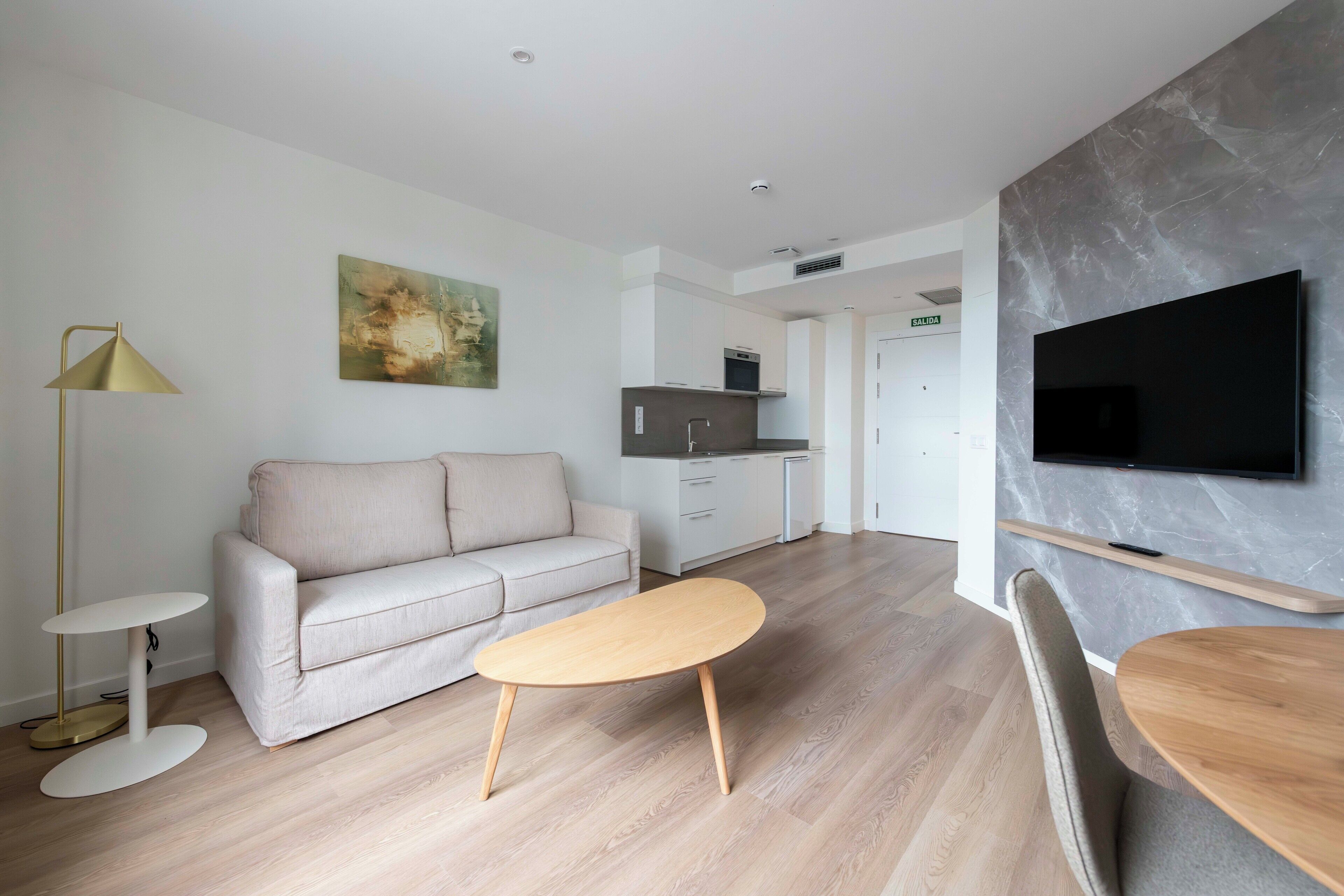 A modern living room with a sofa, coffee table, and TV.