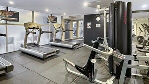 Una palestra con tapis roulant, macchinari per pesi e attrezzature per esercizi.