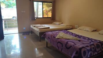 A hotel room with two beds, a large window, and a door leading to a balcony.