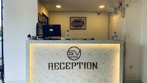 Ein Empfangstresen mit Marmoroptik und dem Schriftzug "SV HOTEL RECEPTION".