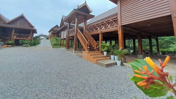 A series of wooden buildings with covered walkways and stairs leading to the entrance. - Vangnamthip Meung Feung Hotel (Ban Don)