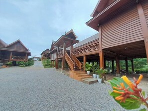 A series of wooden buildings with covered walkways and stairs leading to the entrance. - Vangnamthip Meung Feung Hotel (Ban Don)