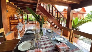 A wooden dining area with a checkered tablecloth, set for a meal. - Vangnamthip Meung Feung Hotel (Ban Don)