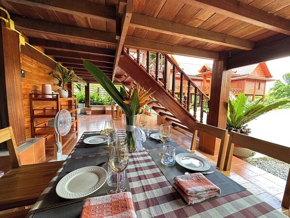 A wooden dining area with a checkered tablecloth, set for a meal. - Vangnamthip Meung Feung Hotel (Ban Don)