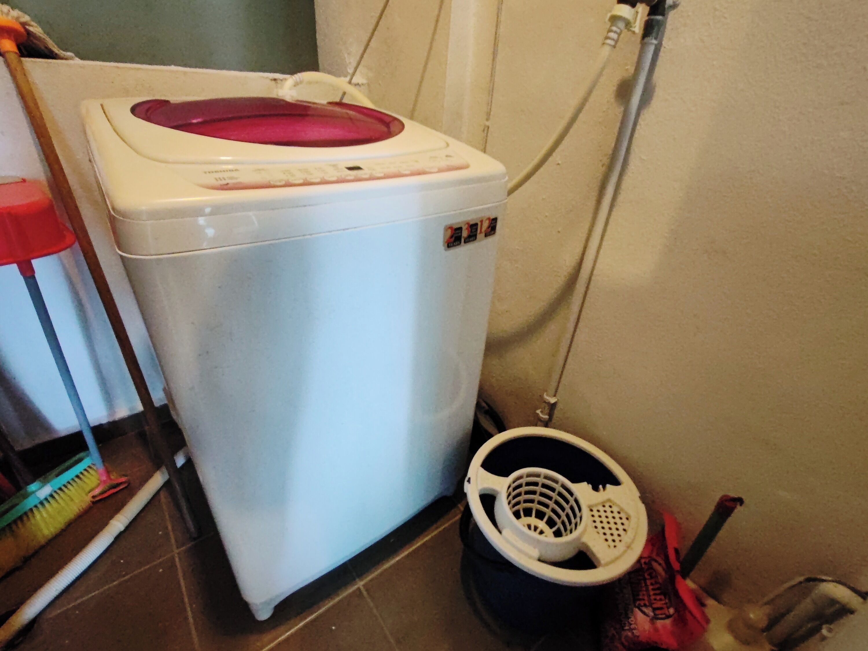A compact washing machine with a red lid, a white control panel, and a power cord.