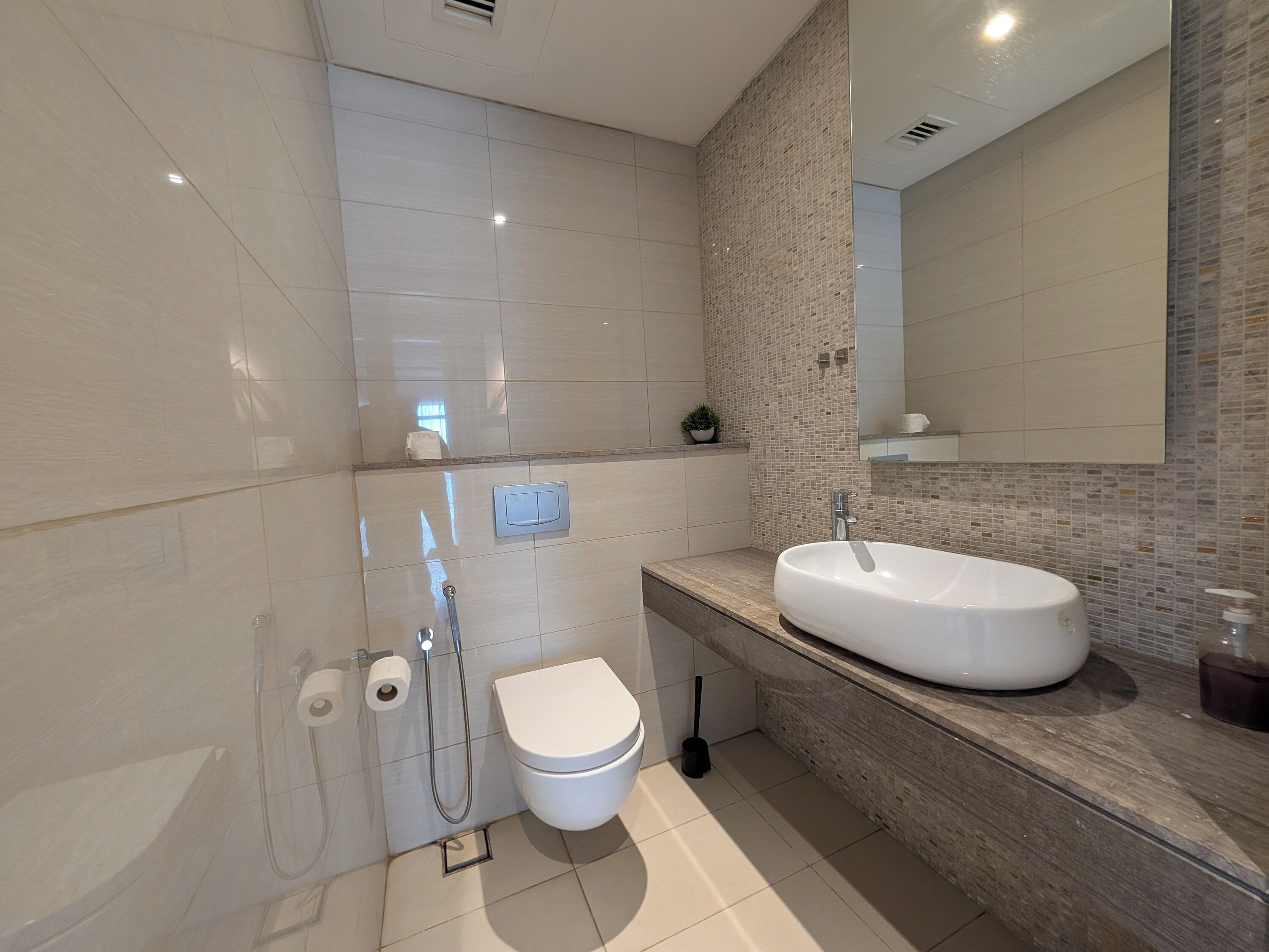 Ein modernes Badezimmer mit einem großen Waschbecken, Toilette und Dusche.