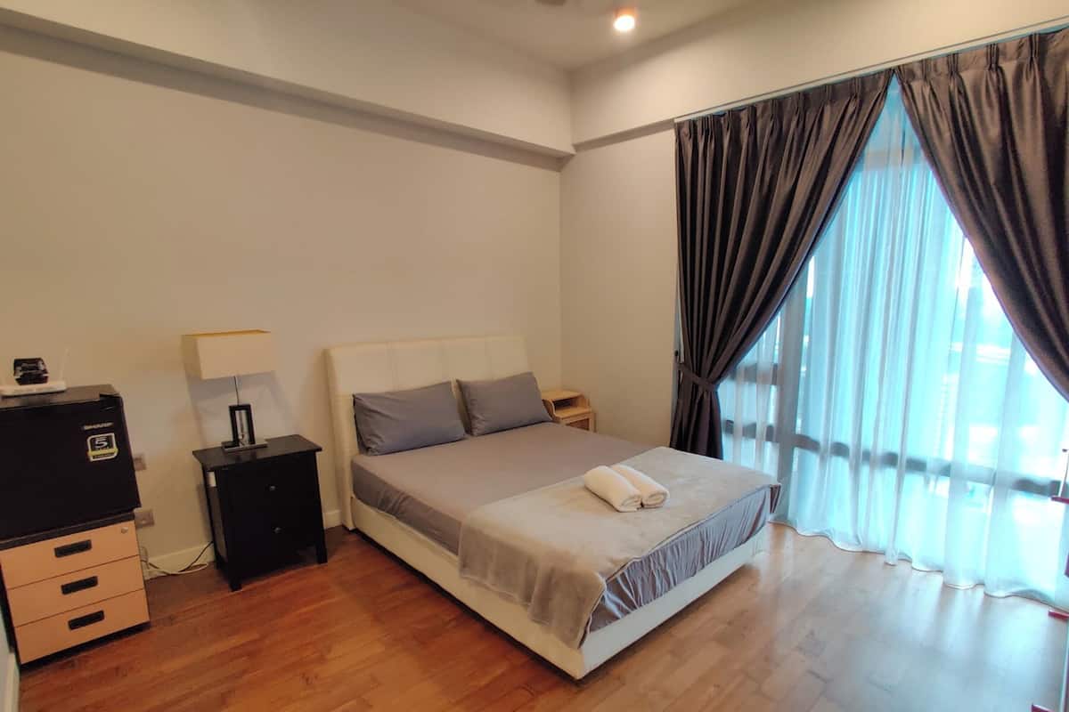 Ein Hotelzimmer mit Bett, Nachttisch, Lampe und Kommode.