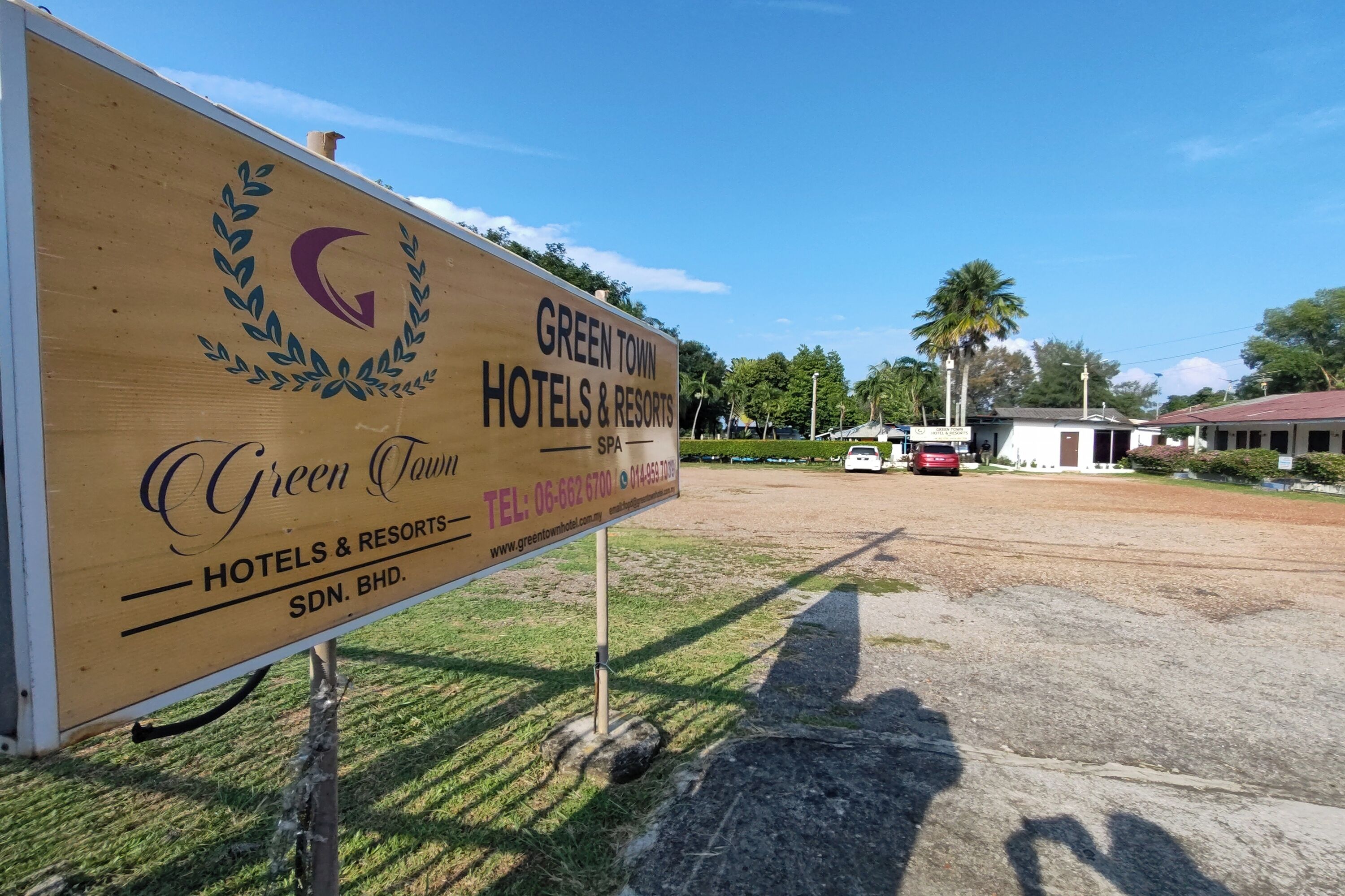 Señal de Green Town Hotels & Resorts con información de contacto y una URL de sitio web.
