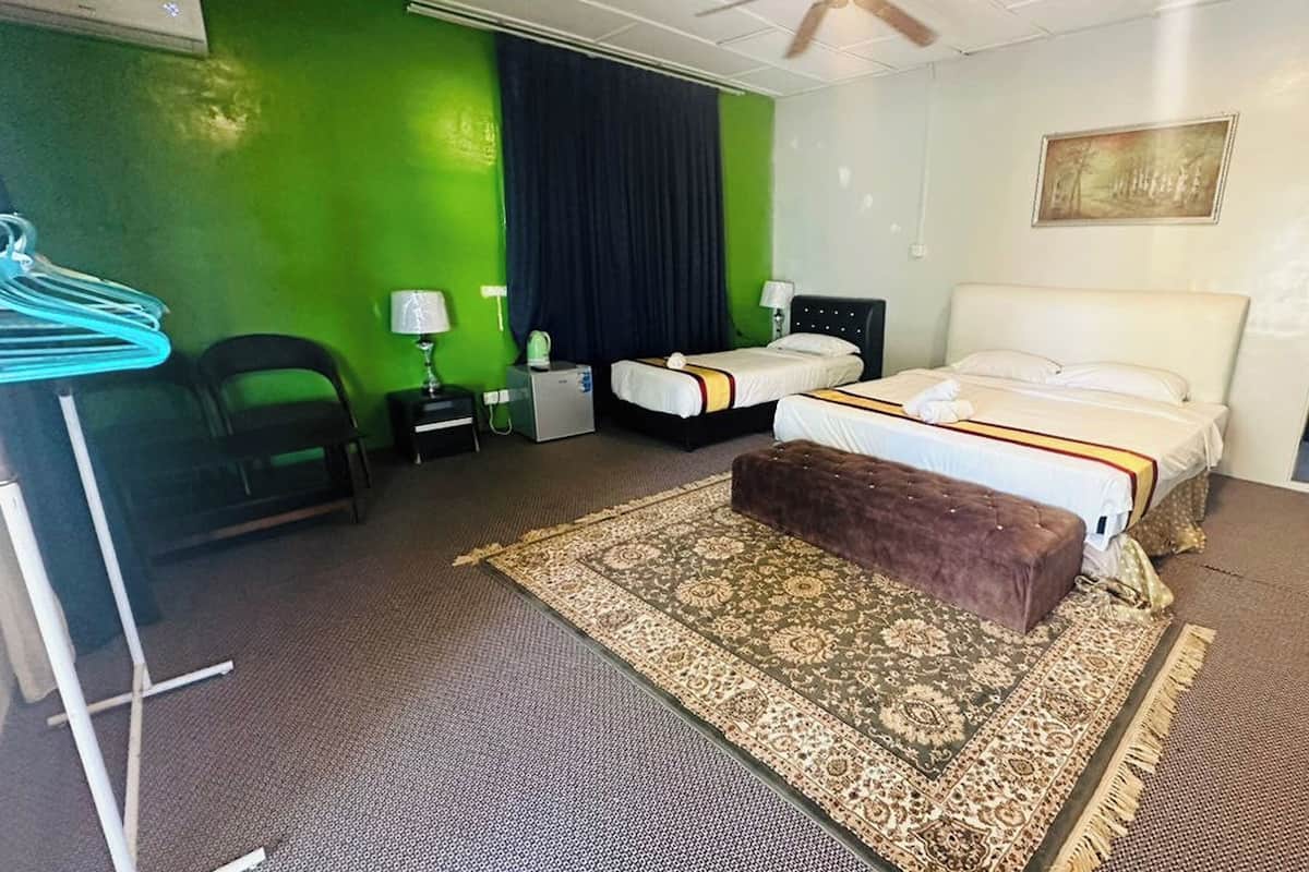 Une chambre d’hôtel avec deux lits, un bureau, une chaise, une petite table et un grand tapis.