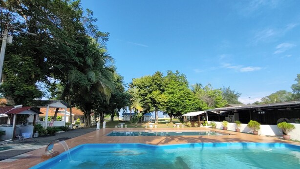 Una piscina con fuente de agua, rodeada de árboles y edificios.