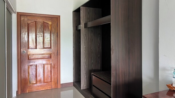Un pasillo con una puerta de madera y un banco empotrado con acabado oscuro.