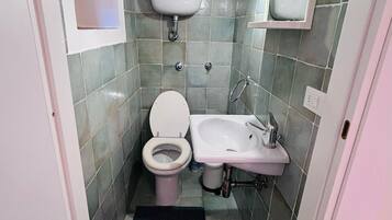 A small bathroom with a toilet, sink, and mirror.