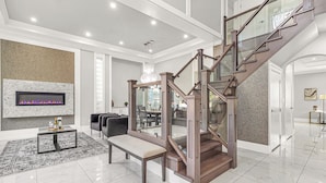 A spacious living area with a fireplace, a staircase, and a seating area.