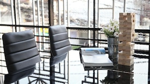 A table with a book, a metal container, and a stack of wooden blocks. - Phukhao Hostel (Chiang Mai)