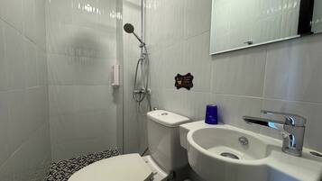 Ein modernes Badezimmer mit Toilette, Waschbecken und Dusche.