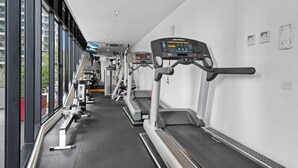 A gym with treadmills, stationary bikes, and weight machines. - Modern 1-bed City Apartment With Pool and Gym (Melbourne)