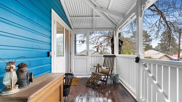 A covered porch with a wooden bench, a chair, and a lantern. - Bright 3-bed House With Garden, (Blackheath)