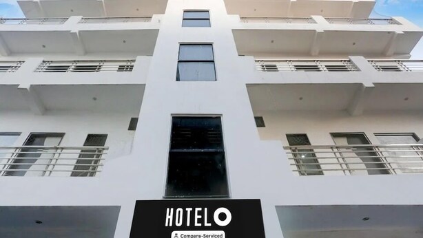 Ein modernes Hotelgebäude mit einem gut sichtbaren "HOTELO"-Schild am Eingang.