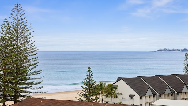A coastal hotel with a beach view, featuring a row of rooms with sloped roofs and a clear view of the ocean. - Glorious Ocean Views, 2-bed, Pool & Amenities (Gold Coast)