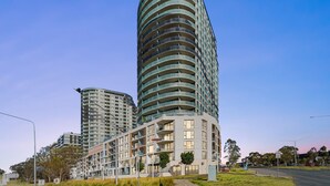 Un edificio moderno de gran altura, con varios balcones y una fachada curva.