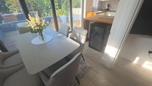 Una cocina moderna con horno integrado, un comedor con mesa y sillas, y vistas al exterior.