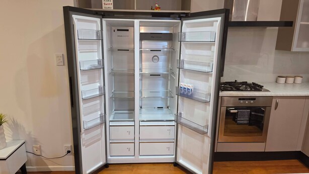 A modern kitchen with a built-in refrigerator, a stove, and a dishwasher. - Northshore Central Cosy & Comfortable 3BR Home (Auckland)