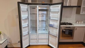Une cuisine moderne équipée d’un réfrigérateur encastré, d’une cuisinière et d’un lave-vaisselle.