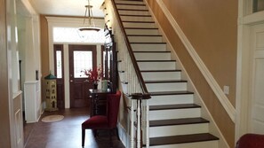 A staircase with white steps and dark railings, leading to a door with a window.