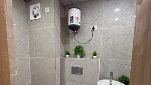 A modern bathroom with a toilet, sink, and shower. - Charming bed & breakfast in enchanting Greater Noida with AC (Greater Noida)