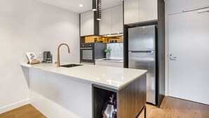 Una cocina moderna con una isla central, electrodomésticos de acero inoxidable y un diseño minimalista.