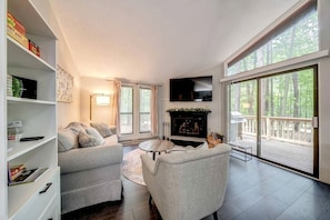A modern living room with a fireplace, a sofa, a coffee table, and a TV.